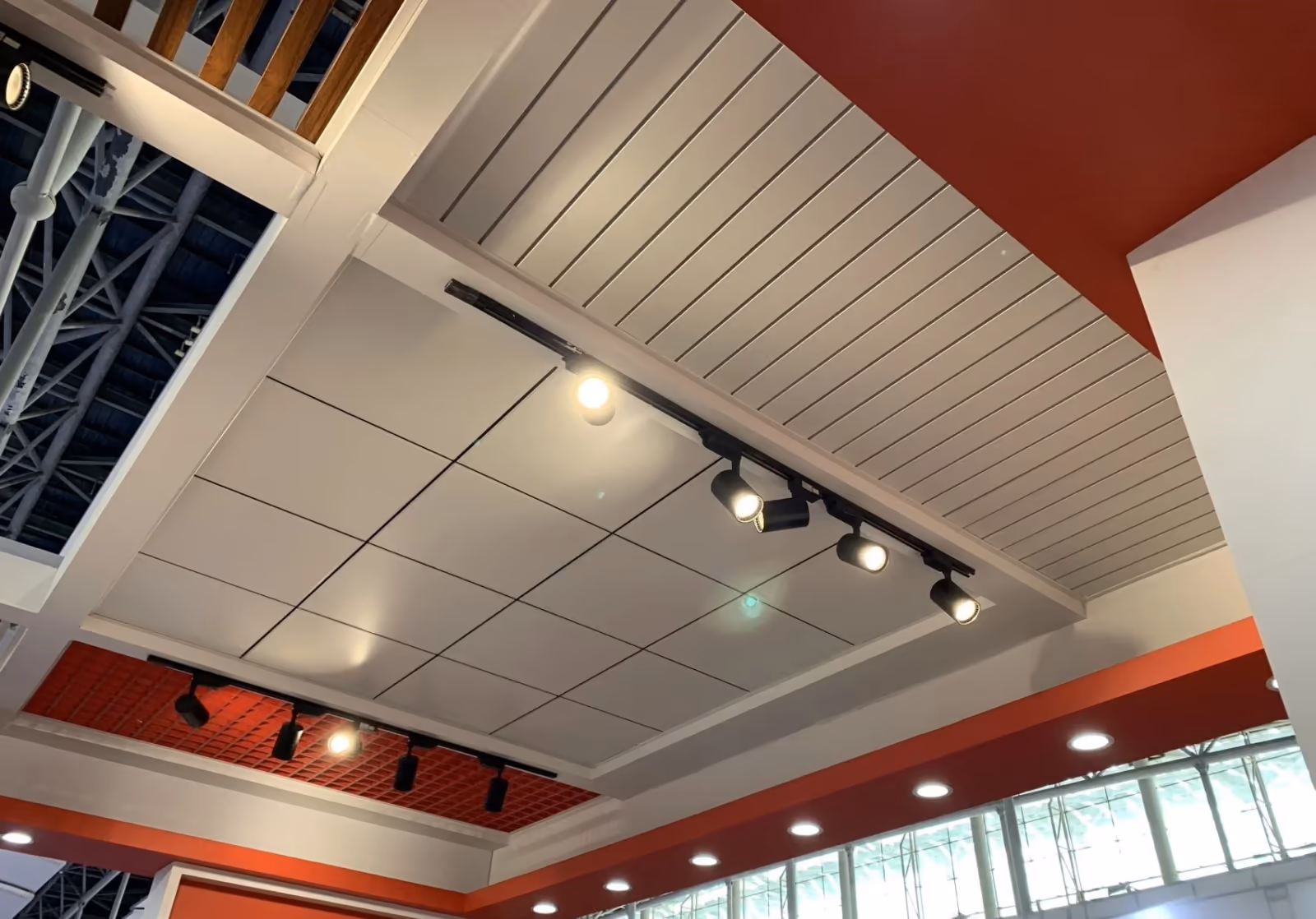Metal ceiling reflecting track lighting over a bright interior