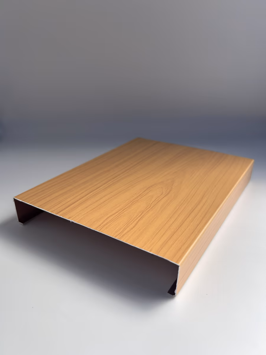 Cut sample of a 6" wide H-shaped aluminum strip panel in a wood grain finish, angled to show the open channel
