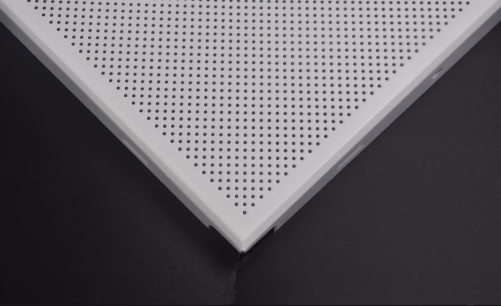 Corner of a perforated clip-in panel showing the folded edge