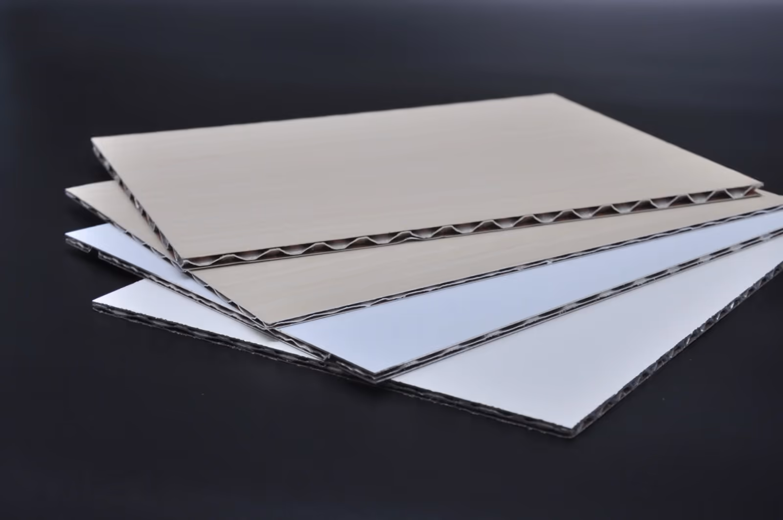 Edges of finished honeycomb panels stacked on a dark ground