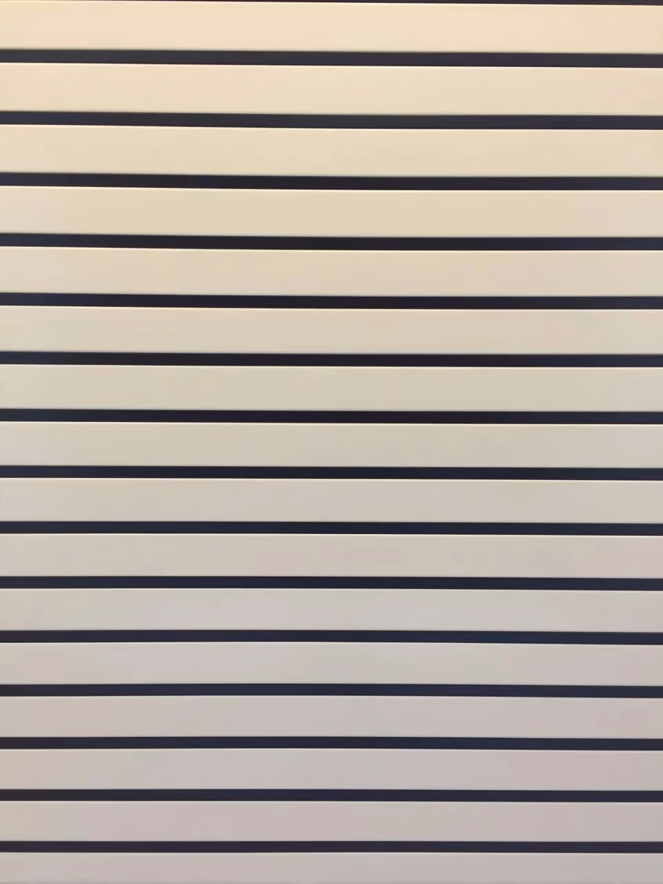 Cream and dark strip ceiling panels alternating across a soffit
