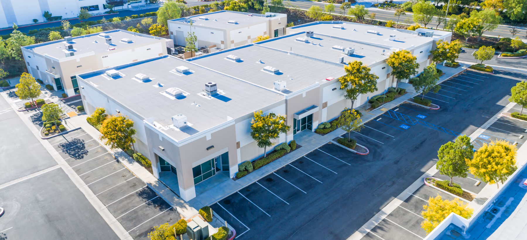 Aerial view of a light industrial park with flat-roofed buildings and loading areas