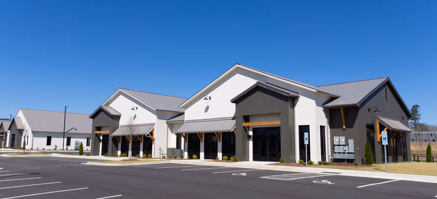 Newly built retail center with gabled storefronts and a parking lot